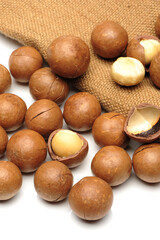 Wall Mural - Shelled and unshelled macadamia nuts on white background
