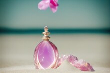  A Bottle Of Perfume Sitting On A Beach Next To A Flower And A Rock On The Sand With A Pink Flower In The Background.