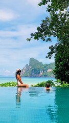 Wall Mural - Asian Thai women in badsuit and caucasian men on the edge of an infinity pool at Koh Phi Phi Thailand.