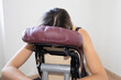 Massage therapist girl massaging female back sitting on massage seated specialist on knee massage chair adapted seat