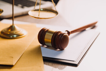 Justice and law concept.Male judge in a courtroom with the gavel, working with, computer and docking keyboard, eyeglasses, on table in morning light