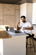 © dianagrytsku - Modern job lifestyle. . Millennial guy using computer and drinking morning coffee, empty space.