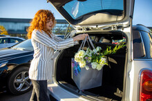 Ginger Young Woman Putting Bags Into The Car