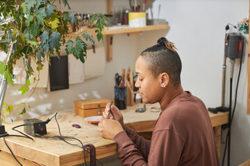 Wall Mural - Side view portrait of female artist shaping molds while creating handmade studio in workshop, copy space