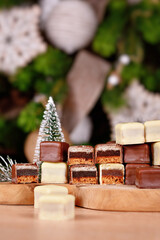 Wall Mural - Traditional German sweets called 'Dominosteine'. Christmas candy consisting of gingerbread, jelly and marzipan layers covered with brown and white chocolate icing