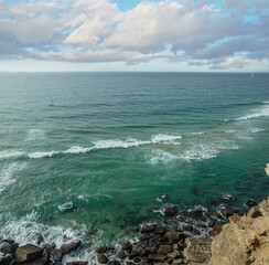 Wall Mural - rocky coastline, ocean and cloudy sky above it. beautiful nature background.