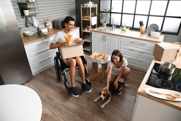 Sticker - Young woman with her husband in wheelchair and dog in kitchen on moving day