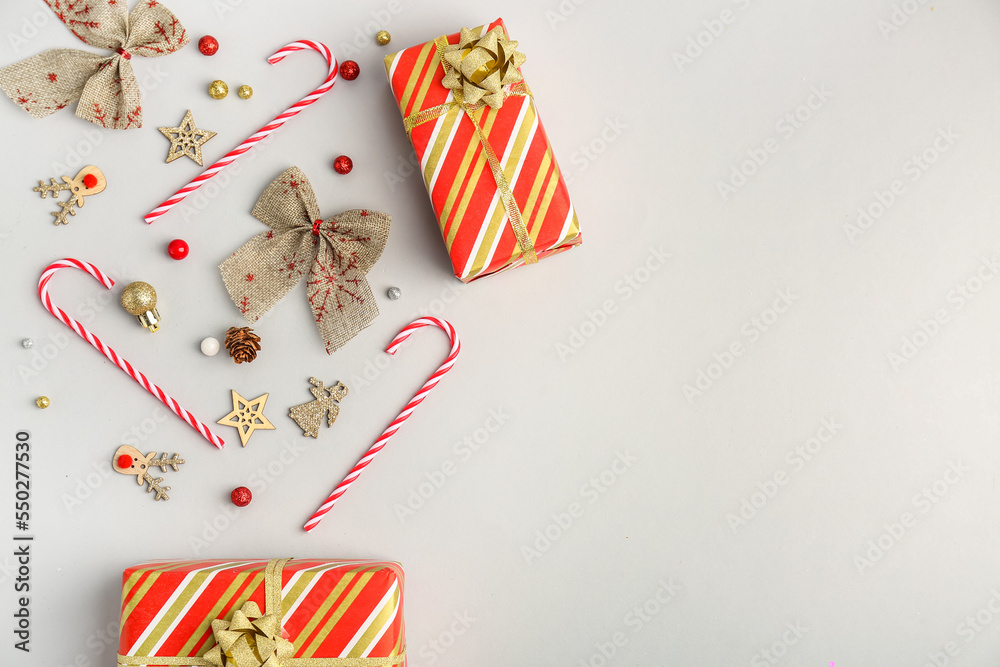 Composition with gifts, candy canes and Christmas decorations on white background