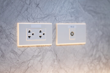 Power outlet socket on white floor wall