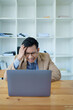 © Jirapong - Portrait of sme business owner, man using computer and financial statements Anxious expression on expanding the market to increase the ability to invest in business