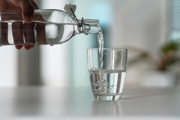 Wall Mural - Pour the water from the water bottle into the glass