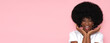 Positive female model with afro hair in white t-shirt on isolated pink background.