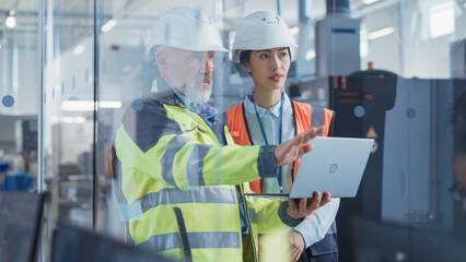 Poster - Asian Quality Control Specialist Conducting an Industrial Facility Check with the Help of Middle Aged Engineer in a Research and Development Factory. Engineers Shows Work Reports on Laptop Computer.