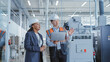 © Gorodenkoff - Two Professional Heavy Industry Employees in Hard Hats at Factory. Checking and Discussing Industrial Facility, Working on Laptop Computer. African American Engineer and Asian Technician at Work.