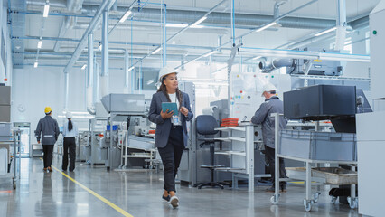 Poster - Portrait of a Black Female Engineer in Hard Hat Walking and Using Laptop Computer at Electronic Manufacturing Factory. Technician Working on Daily Tasks and Research and Development Data.