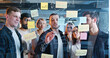 © ihorvsn - Team of startup project standing in front of board with tasks and to-do notes, drawing chart and discussing plan. Coworkers brainstorming. Man making graphic of business. Communication network.