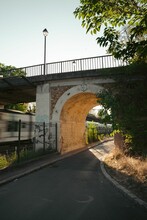 Vertical Shot Of A Small Bridge Over A Narrow Curve Road Near The Train Tracks