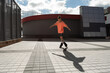© LIGHTFIELD STUDIOS - Young man in roller skates skating near buildings on urban street.