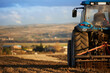 © ADDICTIVE STOCK - Tractor with plow working soil of agricultural field