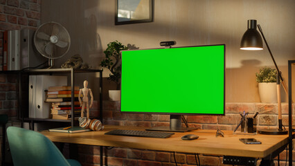 Poster - Modern Personal Computer Monitor with Green Screen Mock Up Display Standing on the Desk with Keyboard, Mouse, Pens, Notebooks and Headphones. Cozy Home Office in Loft Living Room Space.