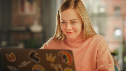 Poster - Attractive Young Woman Working on Laptop Computer while Sitting in Stylish Cozy Creative Office. Freelancer Working Remotely from Home. Browsing Internet, Using Social Networks, Writing Project.