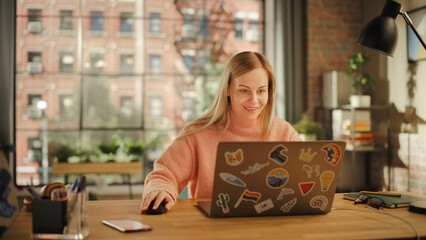 Leinwandbilder - Attractive Young Woman Using Laptop Computer while Sitting in Stylish Cozy Living Room. Female Shopping Online from Home. Browsing Internet, Using Social Networks, Writing Project.