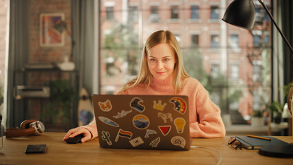 Poster - Beautiful Young Woman Working on Laptop Computer while Sitting in Stylish Cozy Creative Office. Freelancer Working Remotely from Home. Browsing Internet, Using Social Networks, Writing Project.