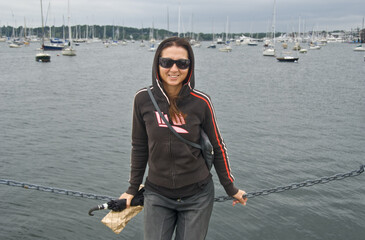 Wall Mural - Happy beautiful brunette caucasian girl visiting Mystic Port in Connecticut, USA