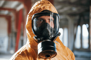 Wall Mural - Portrait of man dressed in chemical protection suit that is in the ruins of the post apocalyptic building