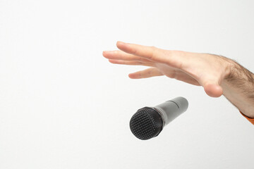 Caucasian male's hand dropping the mic, stretched hand and a microphone