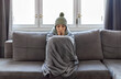 Cold Home. Woman Covered With Blanket Freezing On Couch In Living Room