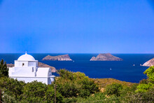 Traditional Chapel With Sailing Boats At The Background, In Milos Island, Cyclades, Greece