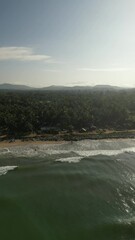 Sticker - Aerial view of the wavy sea and dense forest on the background of mountains