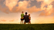 © kieferpix - Fatherhood, and family parenting concept. Father and his children spending time together in nature field looking out to the sunset view.