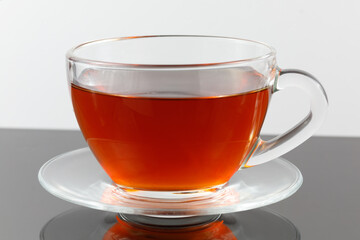 Sticker - Black tea in a cup on a gray background.