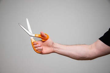 Wall Mural - Man holding an orange scissors