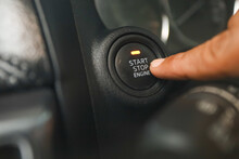 Driver pushes engine start button on modern car.  keyless engine starting system