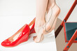 young lady in red dress wearing red shoes on vintage tan stockings feet