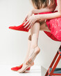 young lady in red dress wearing red shoes on vintage tan stockings feet