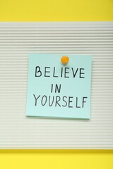 Wall Mural - Note with phrase Believe In Yourself on yellow background, top view. Motivational quote