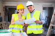 © JackF - Woman engineer and man architect talking about documents, planning repair works in apartment.