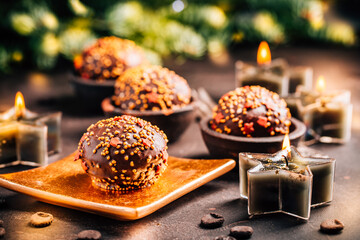 Small chocolate pastry cakes for Christmas with candles and ornaments