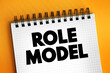 Role model - person whose behaviour, example, or success is or can be emulated by others, text concept on notepad
