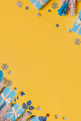Wall Mural - Vertical Christmas flat lay composition from gifts, paper balls and tinsel top view. Ukrainian yellow blue colors. Copy space