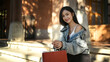 © Prathankarnpap - Portrait of young elegant beautiful Asian woman sitting at urban stairs with shopping bags and smiling to camera
