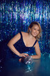 sexy woman blonde in a blue dress in sequins on a blue background blue sparkles holiday birthday, christmas, party. model poses in front of the camera. holds a mirrored disco ball.