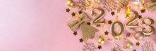 New Year 2023 Celebration Greeting Card Background Gold Numbers 2023 With Golden Party Decoration, Stars Confetti On Pink Background. Flat Lay, Merry Christmas, Noel Happy New Year Holidays Banner