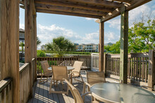 Destin, Florida- Wooden Deck With Coffee Tables And Chairs Against The Lake View