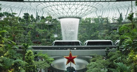 Wall Mural - Airport train pass iconic rain vortex waterfall in Singapore rainforest; static