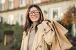 © Andrei - Glamorous woman in fashion glasses with shopping bags and beautiful smile in the street